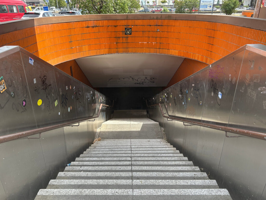 The orange tiles above the stairs to the Messedamm tunnel are worn and broken.